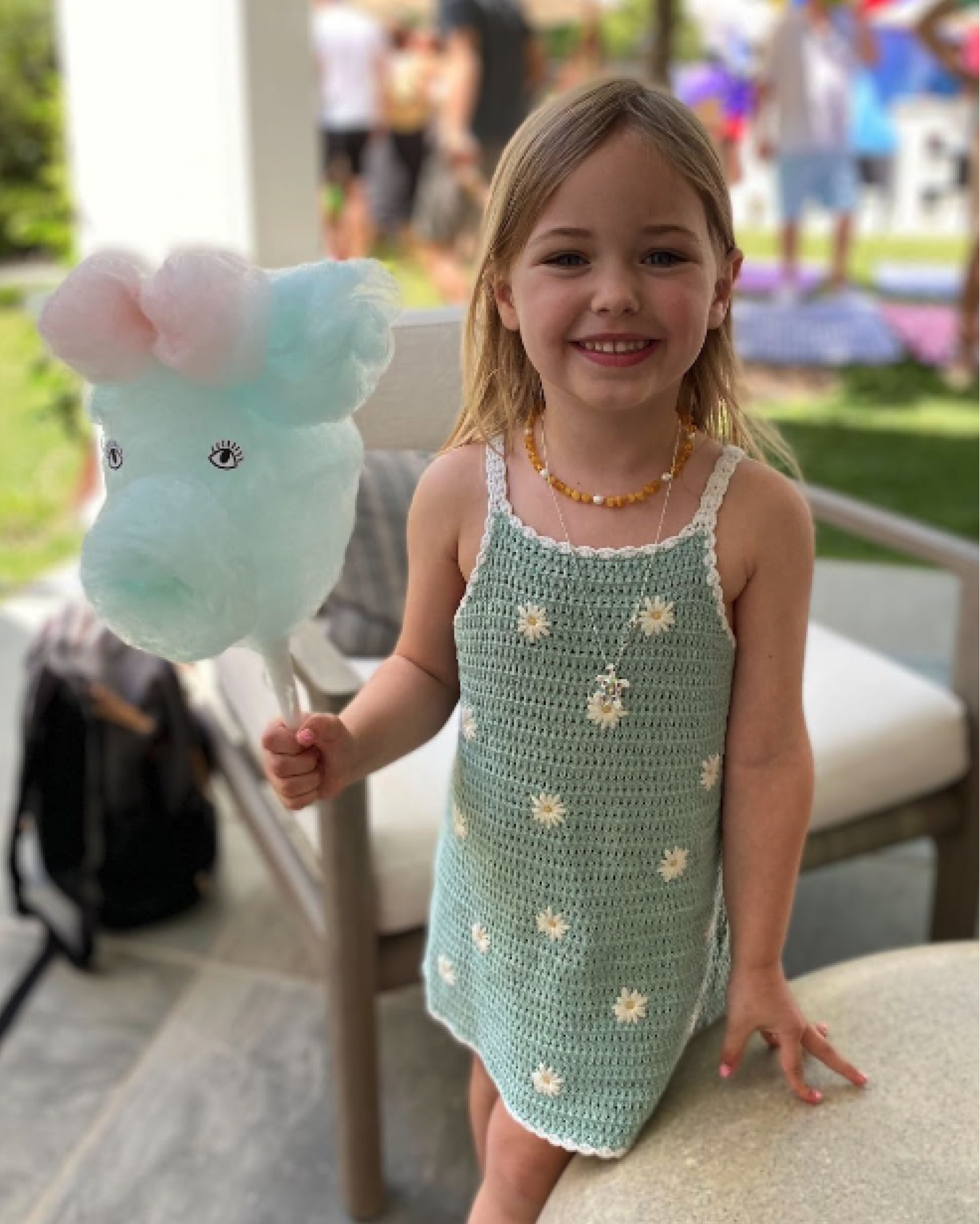 A little girl holding  animal-shaped cotton candy.