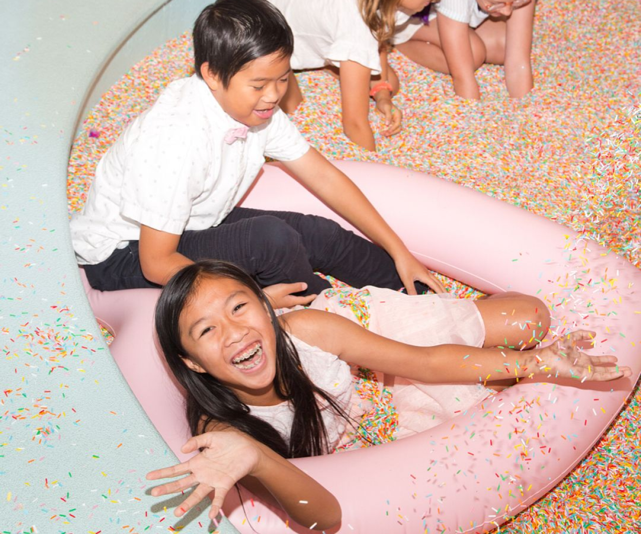 Kids playing in a pit filled with sprinkles.