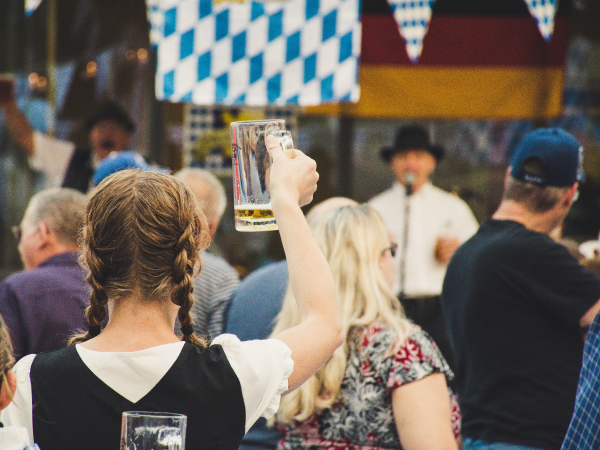 A woman at Oktoberfest holding up a pint of beer.