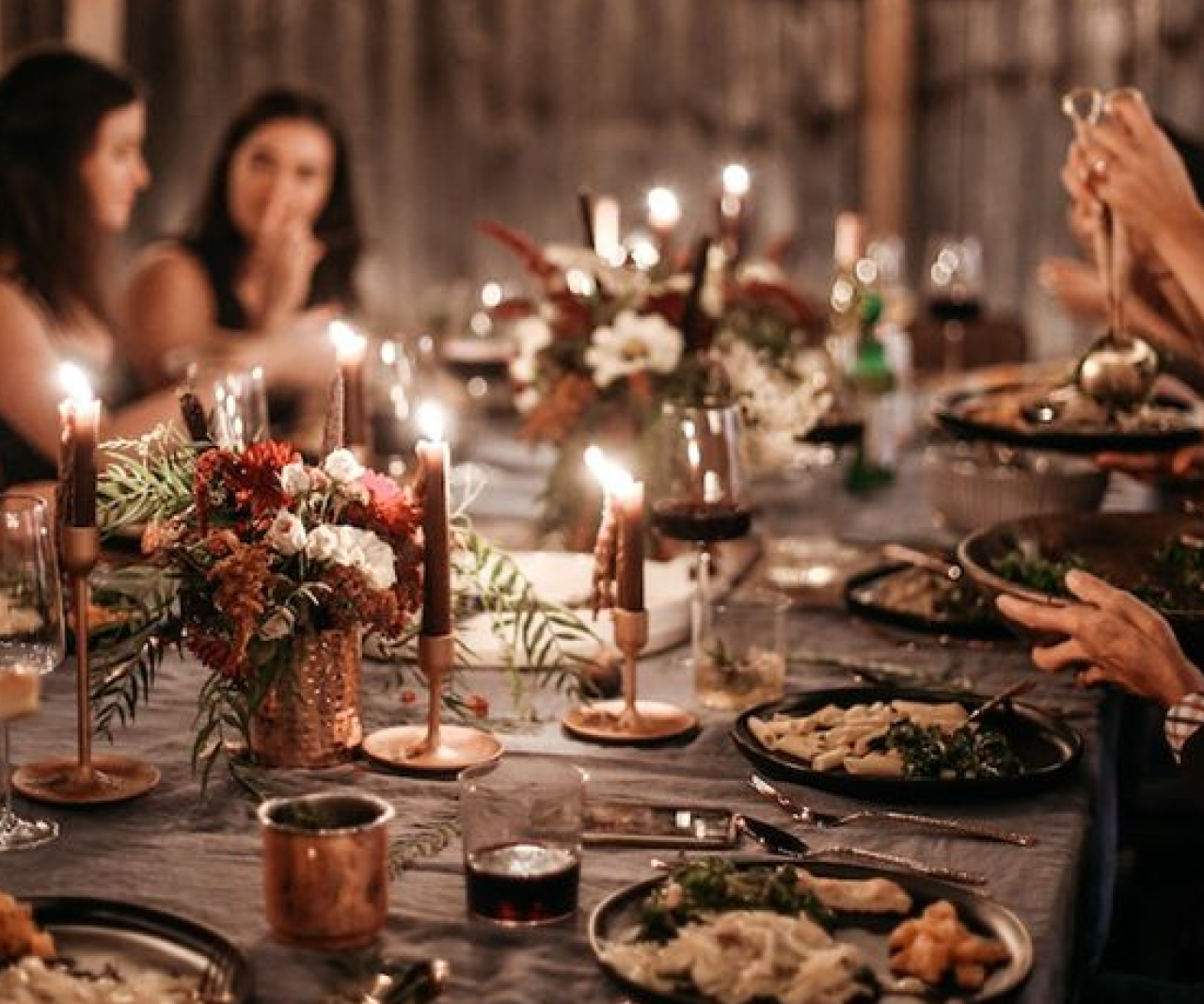 People sitting around table together eating at dinner.