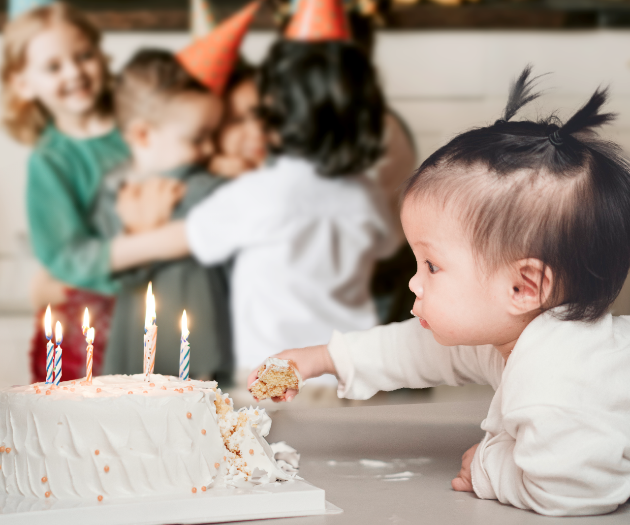 Baby grabbing a handful of someone else's birthday cake.