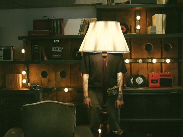 A man standing behind a lamp.